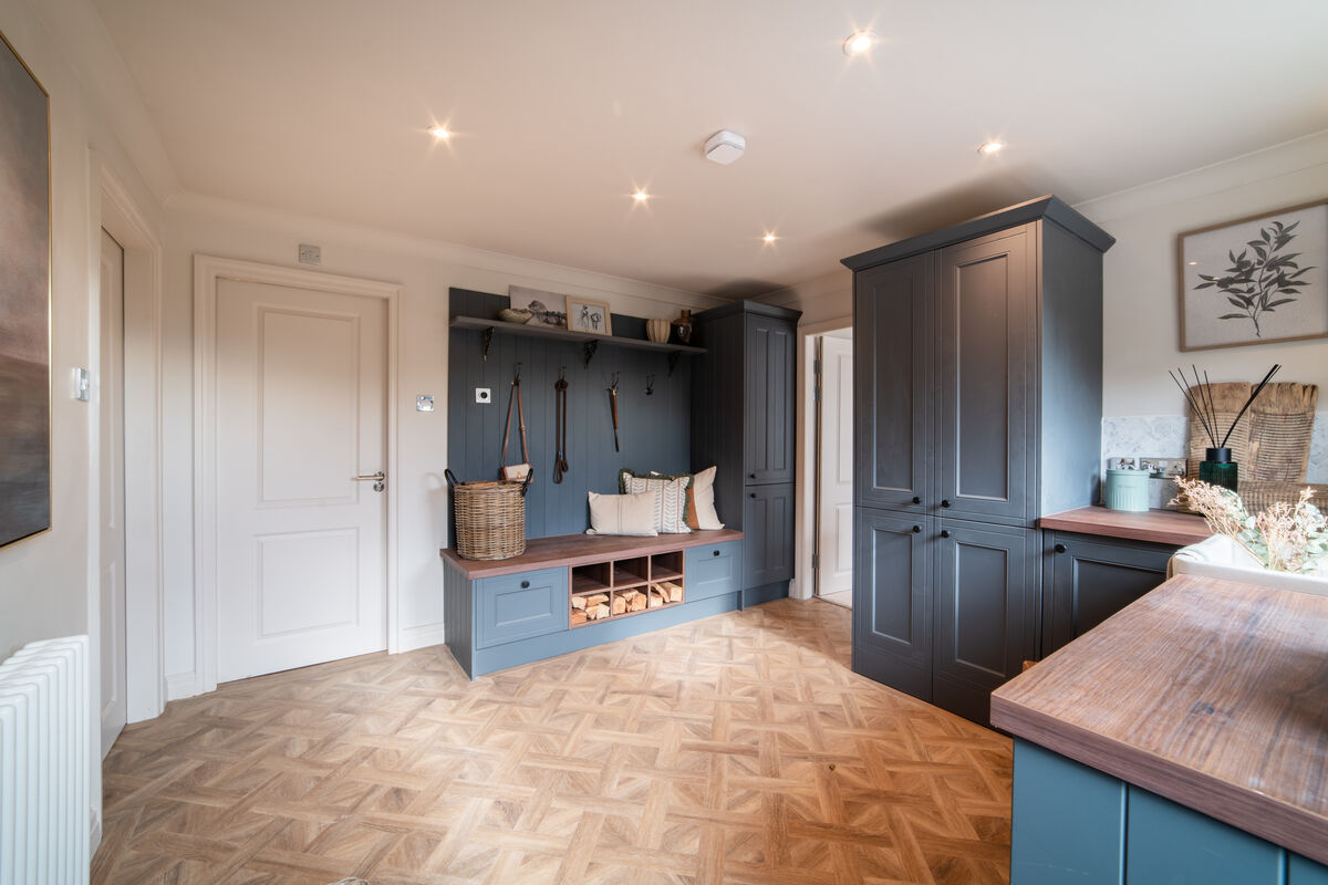 Boot room with dark blue cabinetry, bench seating, coat hooks and shoe storage