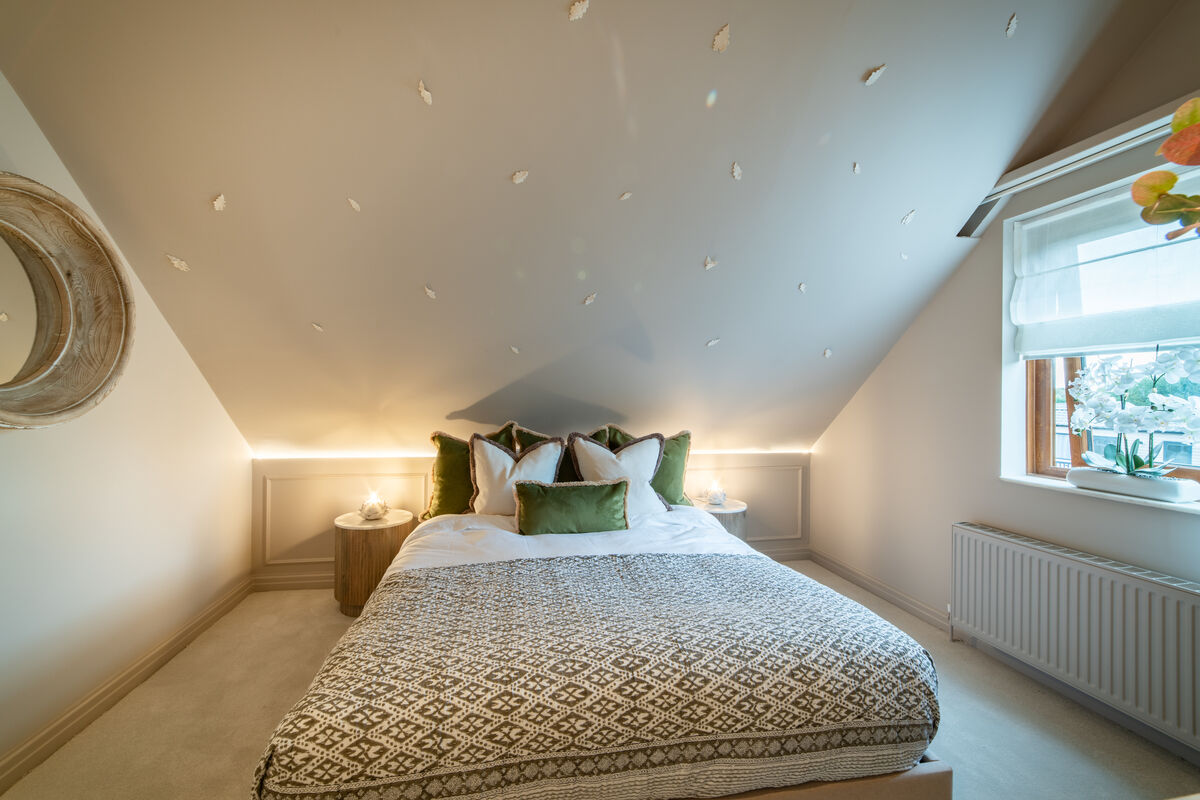 Starlight Suite with star-effect ceiling, patterned bedspread and green cushions