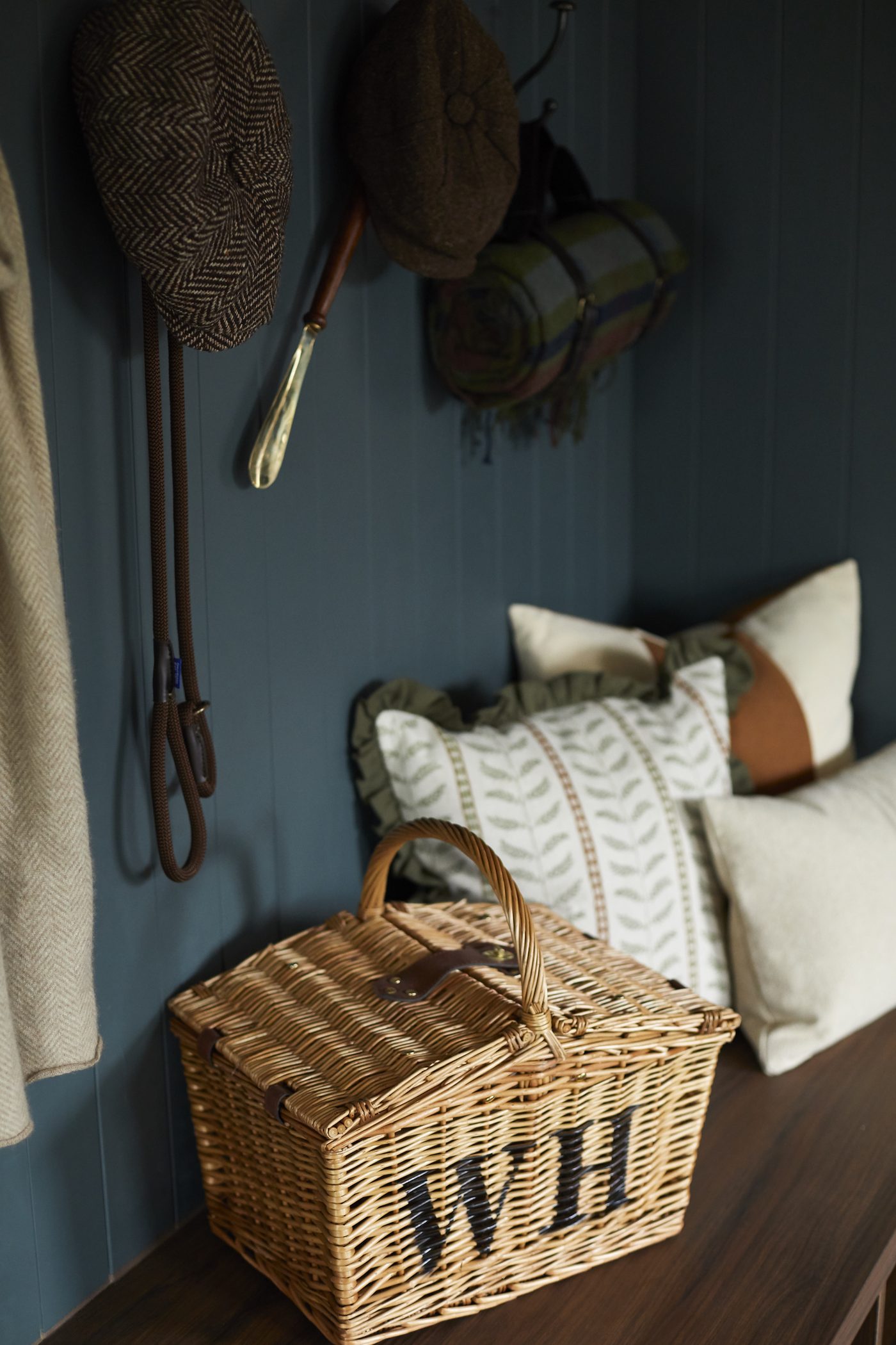 Flat caps and dog leads on the boot room hooks at Warren House