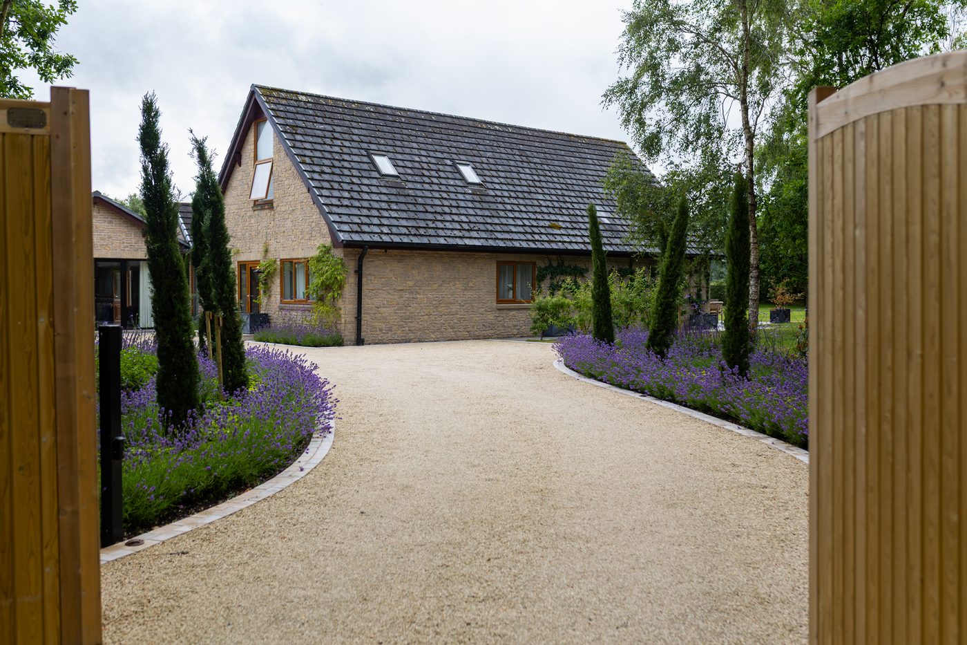 The automatic gates opening onto the cypress-lined drive at Warren House