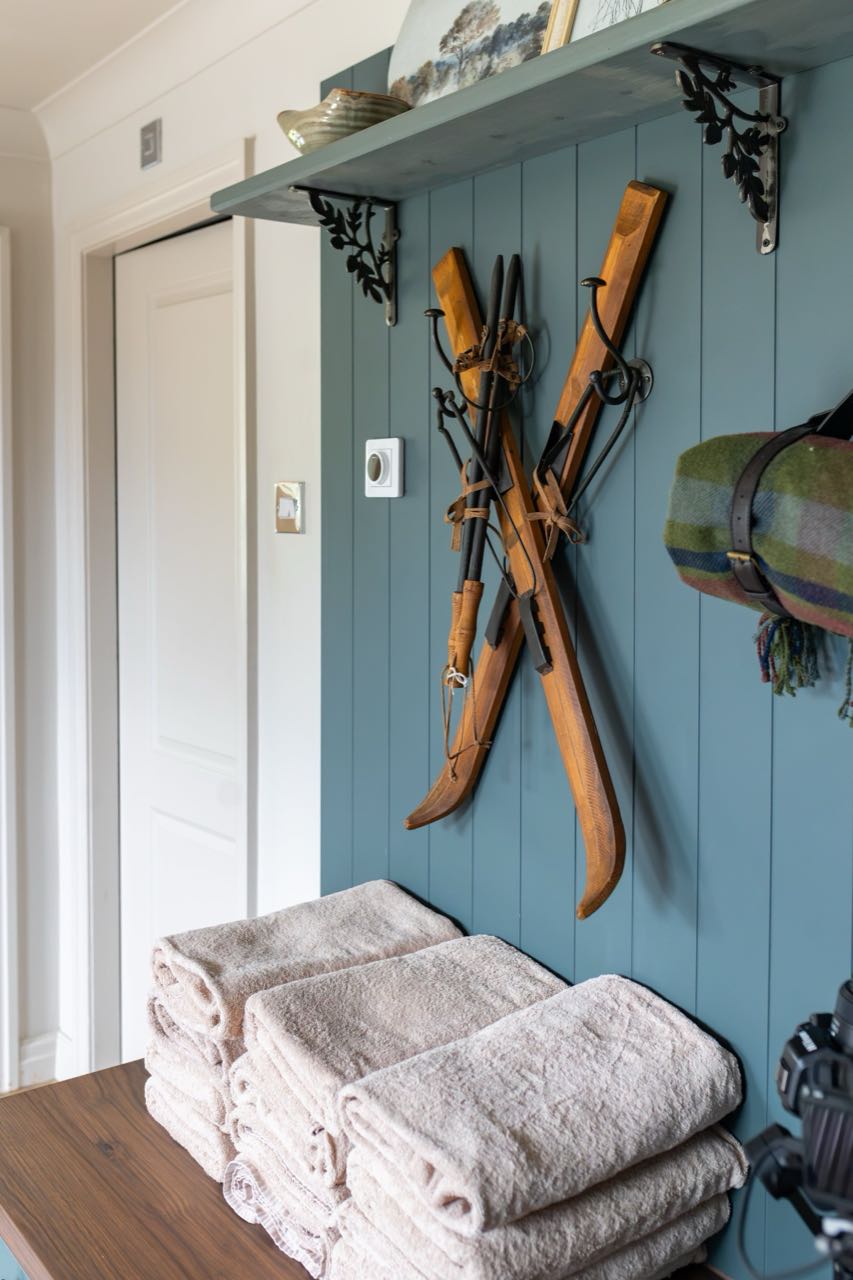 The boot room at Warren House with its dog bed and country hooks