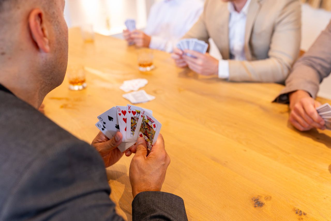 A card game around the oak table at Warren House with whisky poured