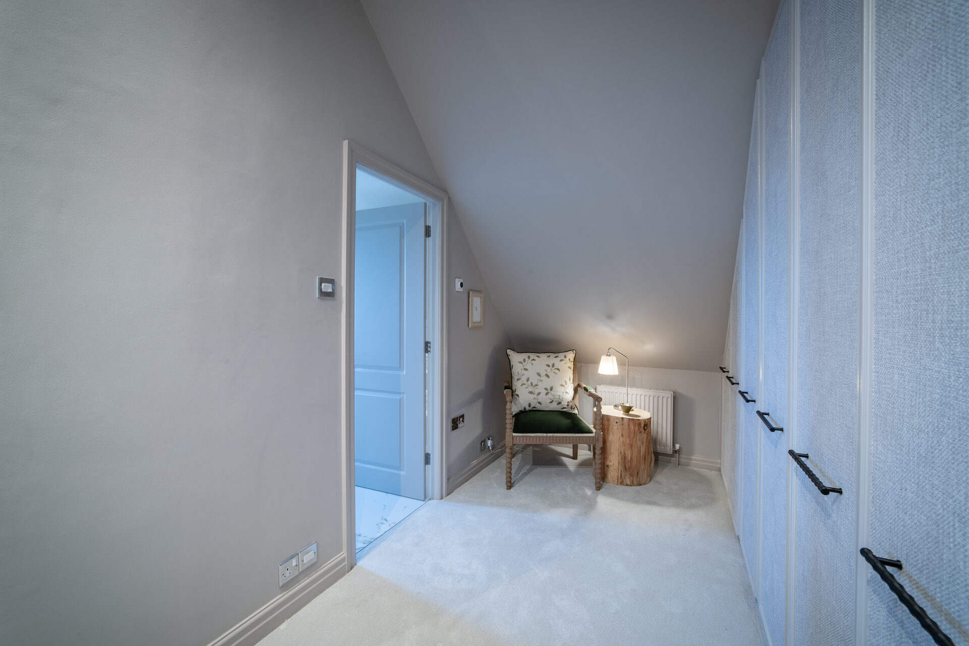 Dressing area with built-in wardrobes, reading chair and tree-trunk side table