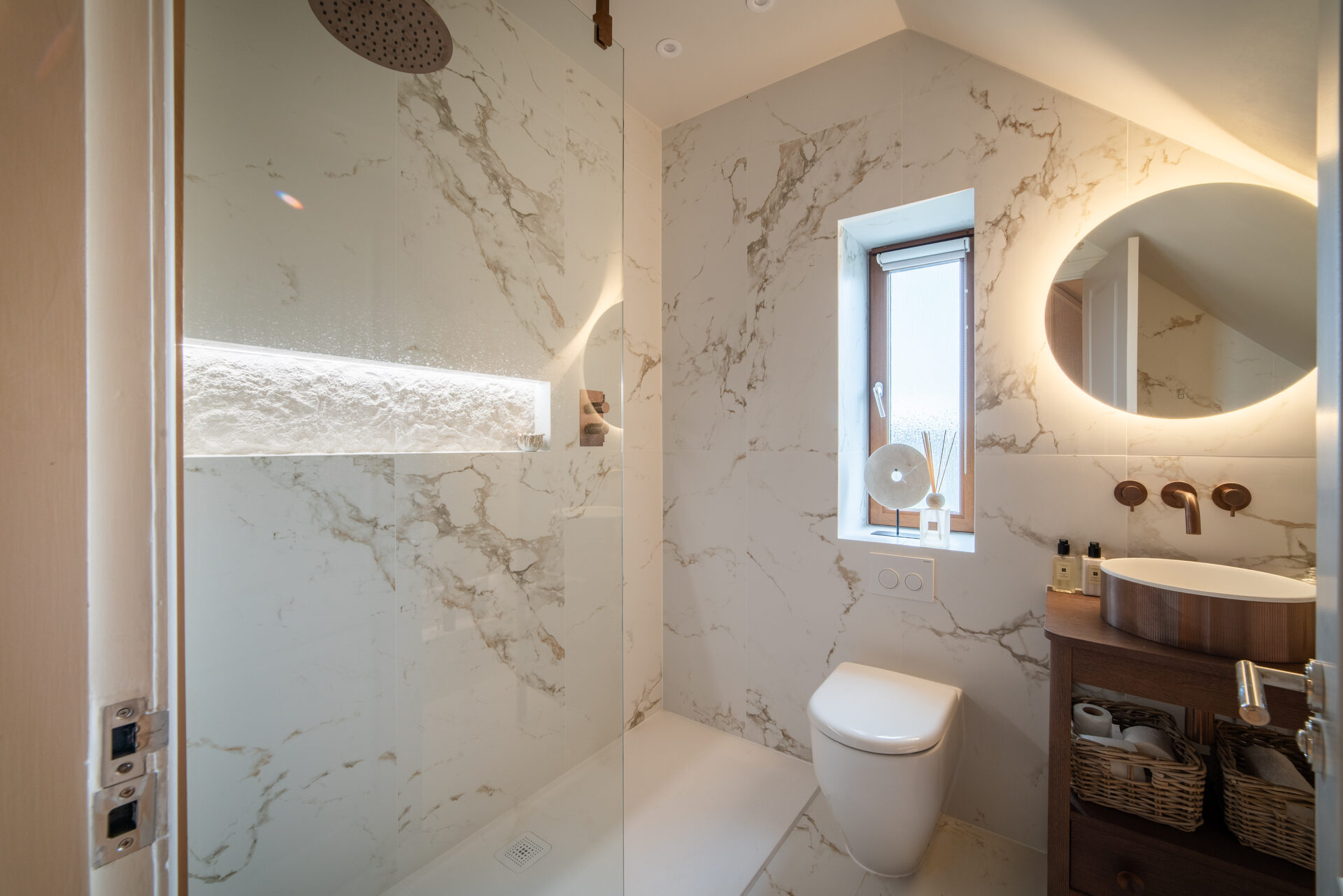 White marble en-suite with rain shower and backlit oval mirror