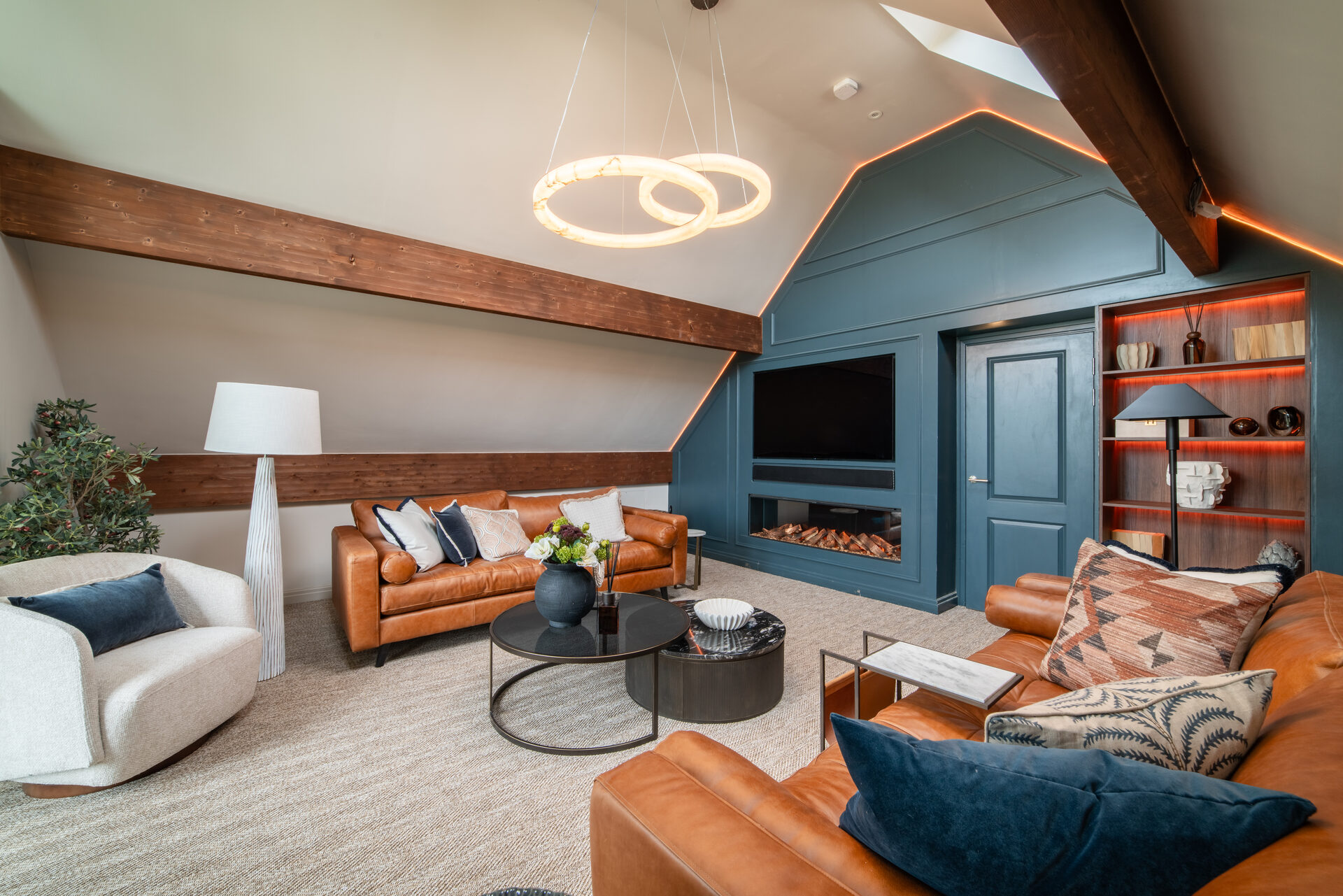 Luxury living room with teal feature wall and tan leather sofas