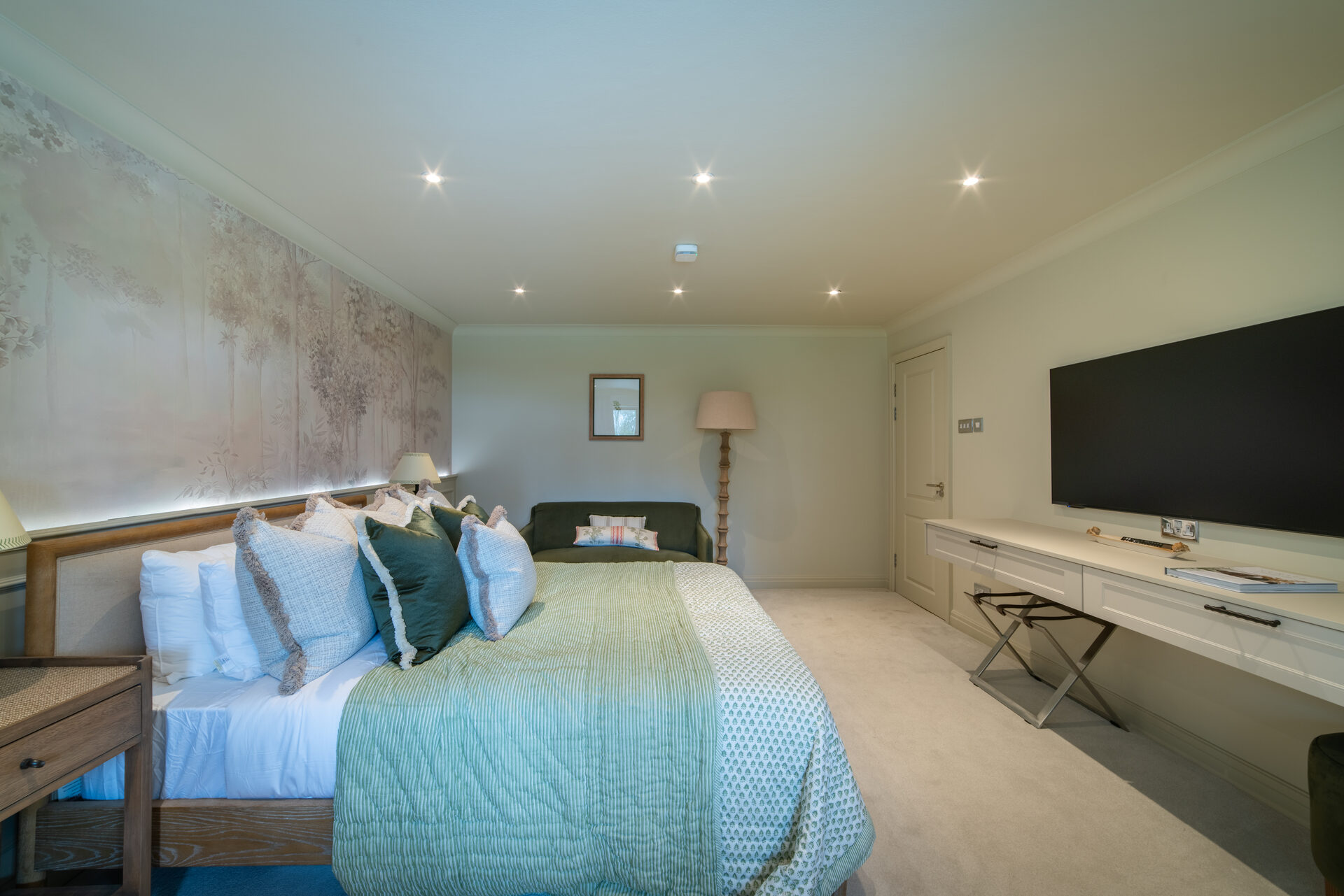 Master bedroom from another angle showing sofa and TV wall